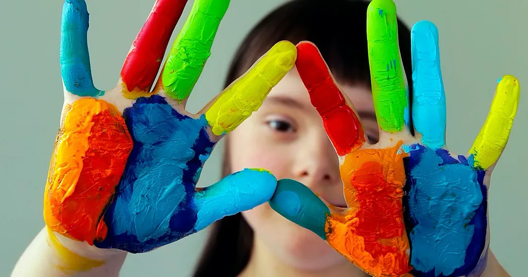 Student with rainbow pain on hands