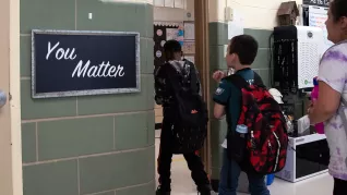 students walk single file out of Ms Tingle's classroom past a sign that says You Matter