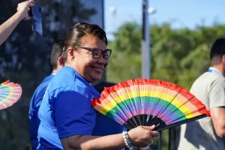 NEA President Princess Moss uses a Pride fan to cool off at the 2023 Freedom to Learn rally in Orlando