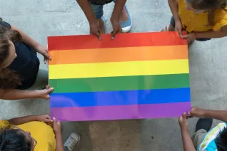 Children hold a Pride flag