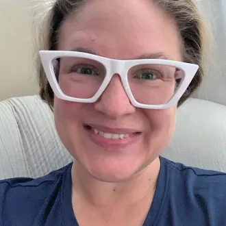 headshot of Leah Hood wearing white framed glasses