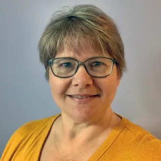 headshot of Nicole Nichols wearing a yellow shirt