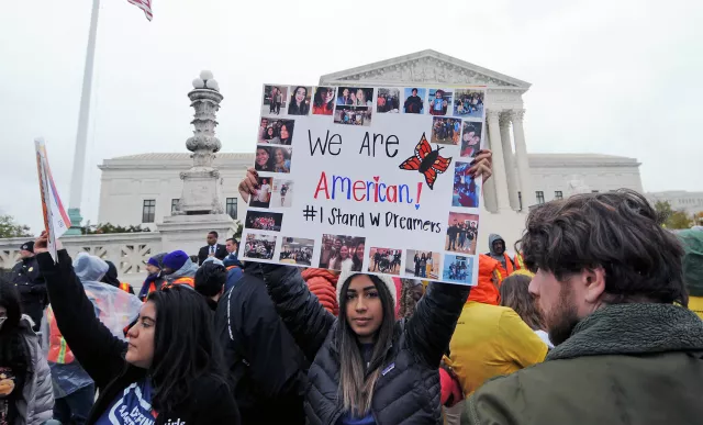 Protester holds up sign that says We Are American at rally in DC