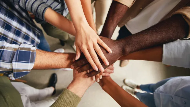 close up of diverse hands stacked on top of each other