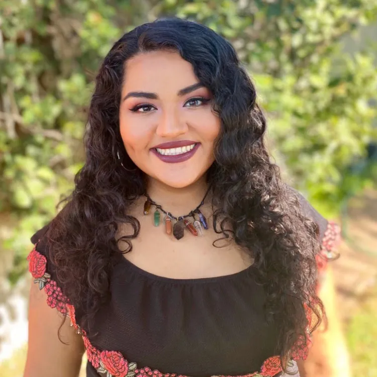 smiling Latina woman in a brown shirt
